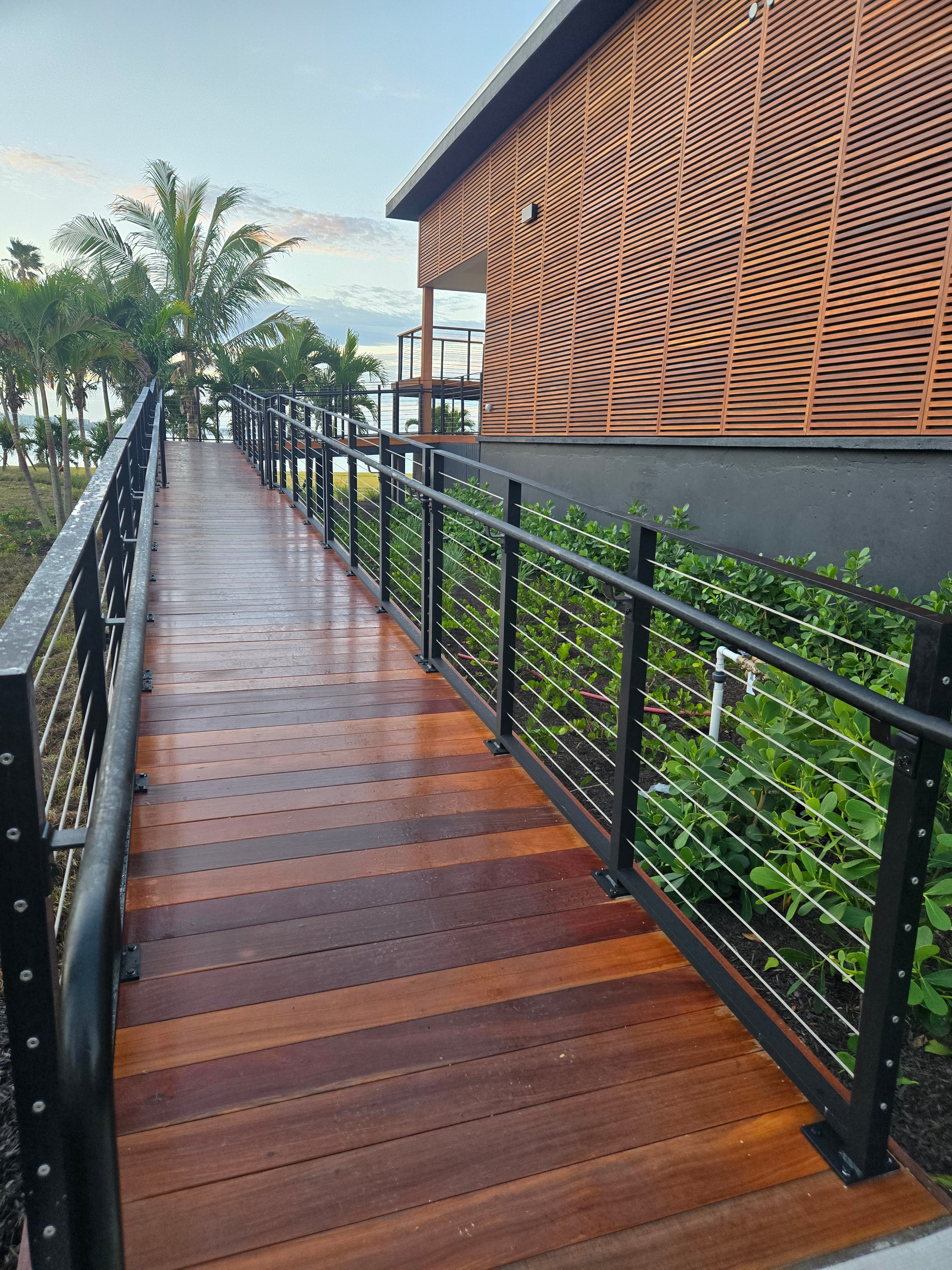 Hardwood boardwalk alongside a tropical building — coastal property