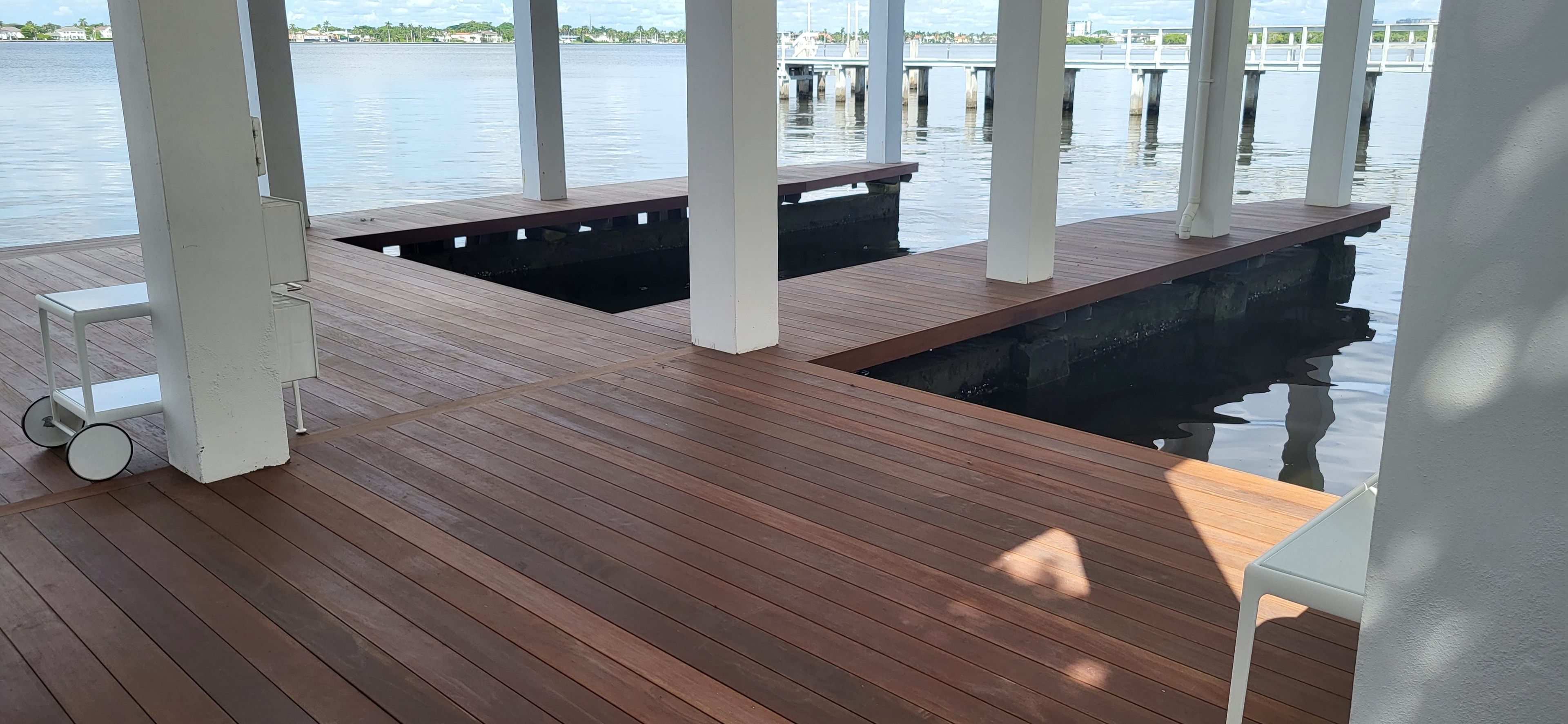Covered waterfront dock with hardwood decking and white columns